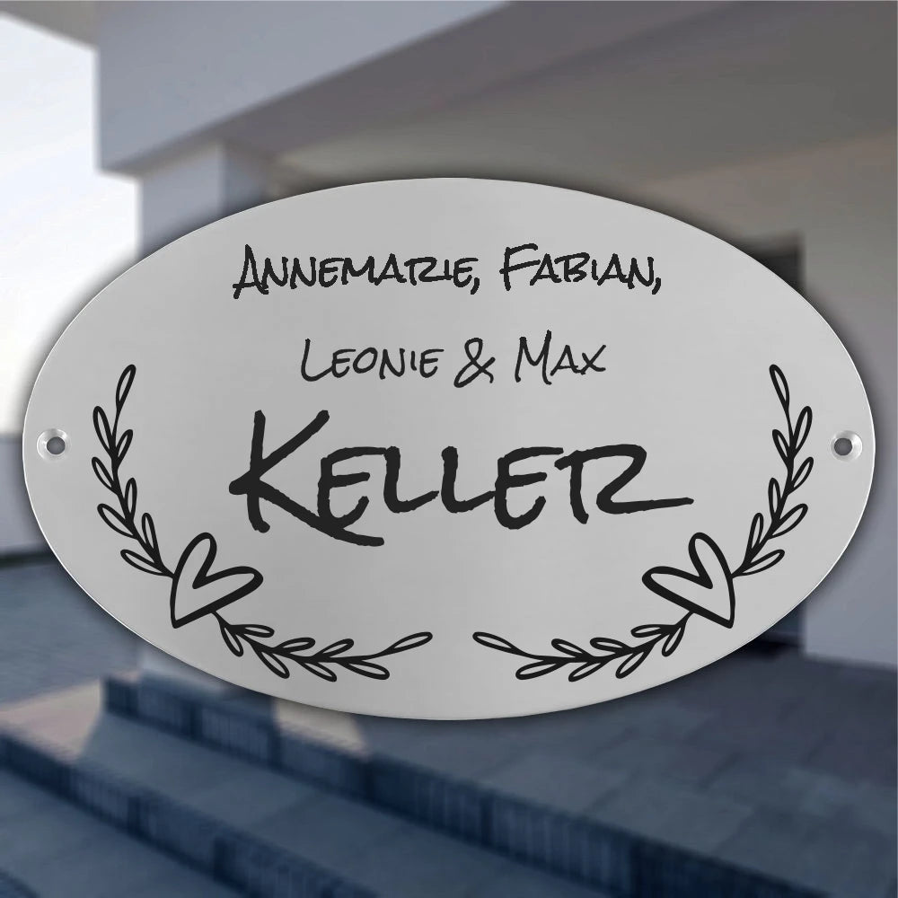 Personalisiertes ovales Türschild aus Edelstahl mit Familienname, Vornamen, Herzmotiv und floralen Ranken